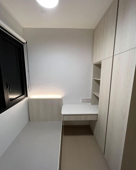 Small study fitted with a pale wood desk return, open shelving and full-height cabinets, with an LED strip under the desk.