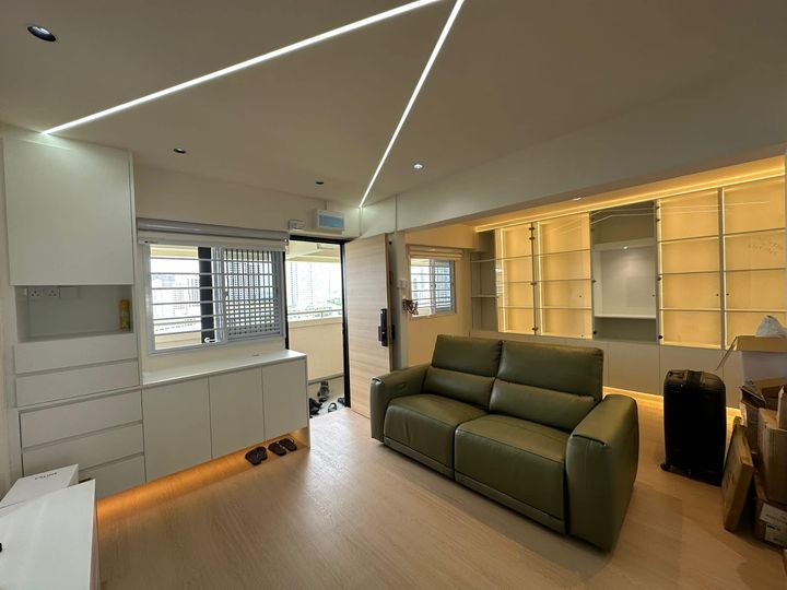 Finished living room with an olive leather sofa, linear LED ceiling channels and a white storage run, renovated by Startec.