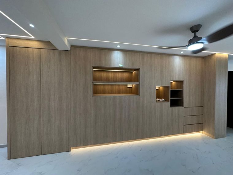 Full-height pale wood-grain carpentry wall in a living room, with concealed doors and two LED-lit display recesses.